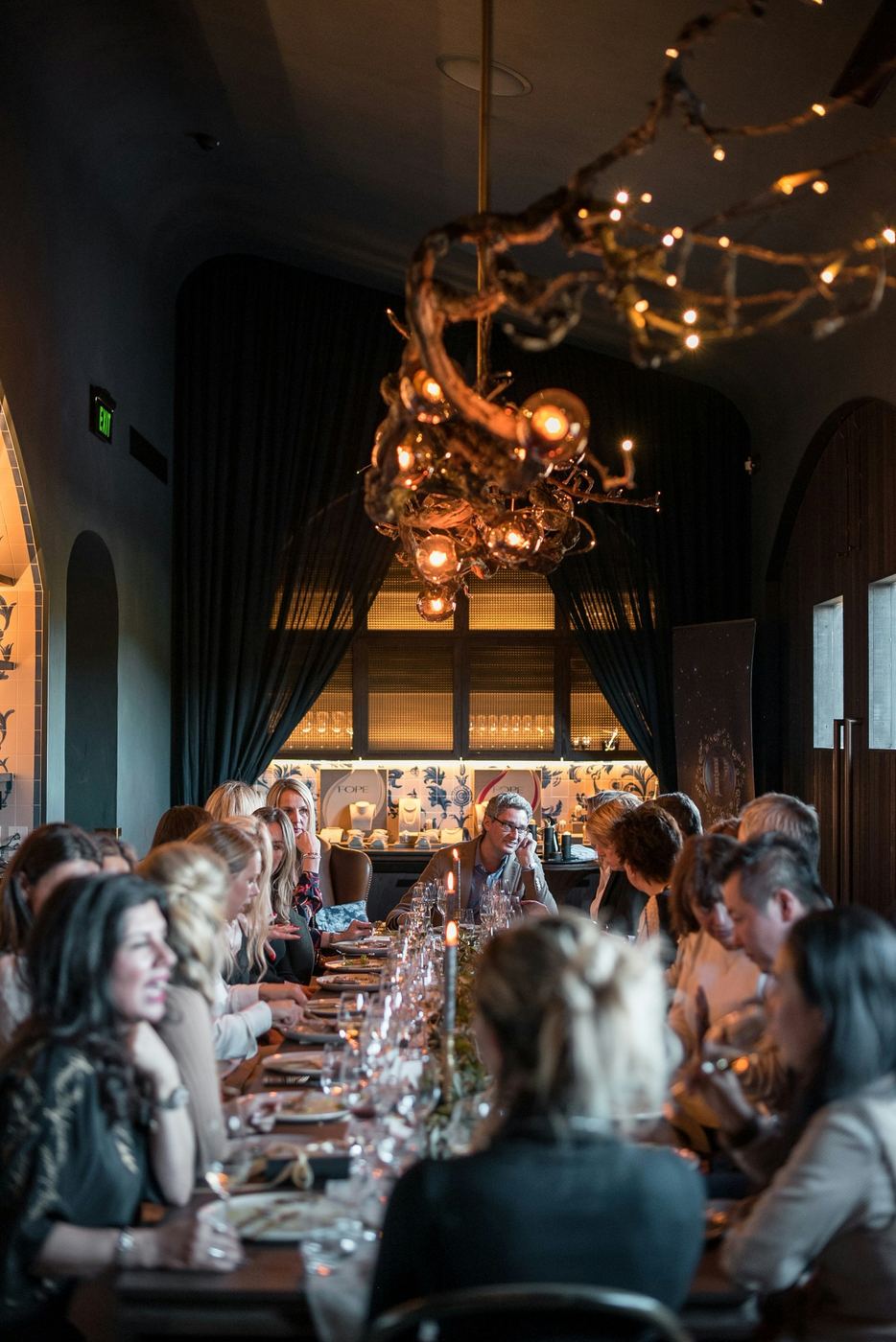 A long table in a dark, candlelit private dining room
